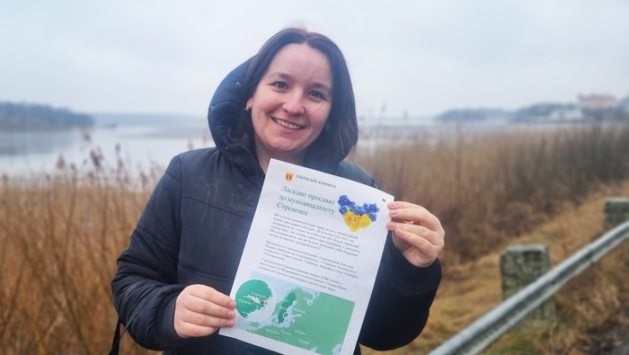 Oksana Moroz, samordnare för Ukrainska flyktingar i Strängnäs kommun. Håller upp ett informationsblad om kommunen skapat för flyktingarna.