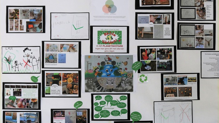 Teckningar och bildcollage om förskolans klimatarbete sitter på en vägg.