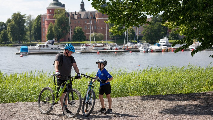 far och son med cykel framför Gripsholms slott