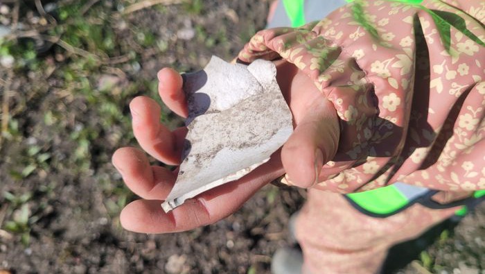 Ett barn har hittat en stor plastbit och visar upp den